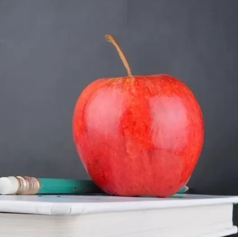 Apple on books with pencil